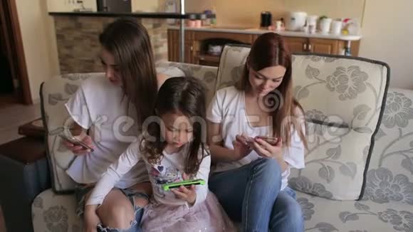 三个姐妹坐在沙发上打电话视频的预览图