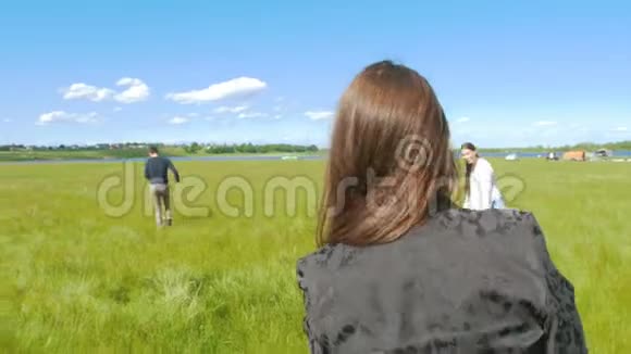 在阳光明媚的日子里年轻的朋友在夏天的田野上玩飞盘视频的预览图