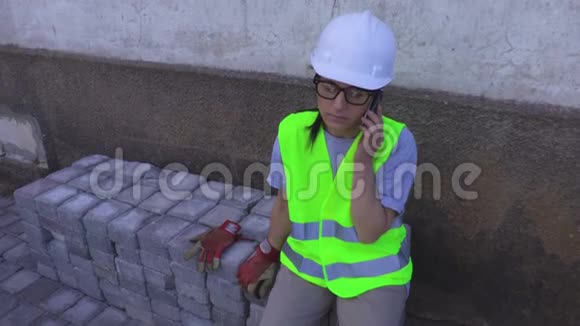 女建筑工用手机说话视频的预览图