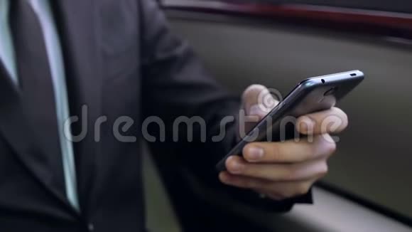 穿西装的男人坐在车后座用智能手机发邮件视频的预览图
