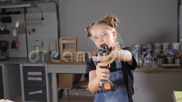 10岁的木木工女的画像手持电子钻对着镜头摆姿势小小的建筑理念高清高清视频的预览图