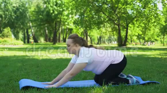 肥胖女孩练习瑜伽减肥计划与自然团结和谐视频的预览图
