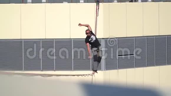 一个人走在两座摩天大楼和瀑布之间的一根紧绳上他被保险救了出来视频的预览图