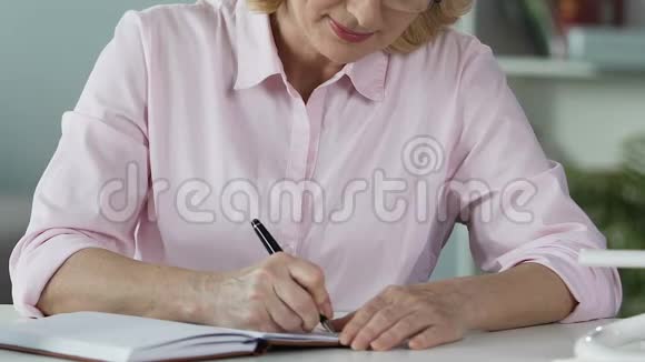 退休女性对创业计划的思考和在笔记本上写下想法视频的预览图