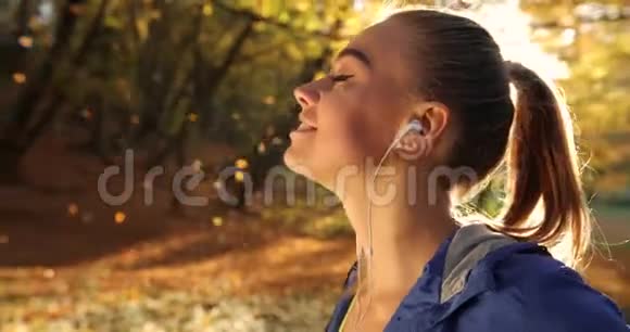 公园里的女跑步者女人喜欢落叶站在清晨的阳光下休息一下视频的预览图