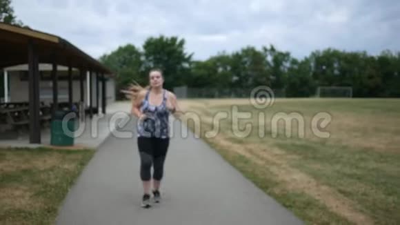 慢跑的女人在公园跑步时会感到腰痛视频的预览图