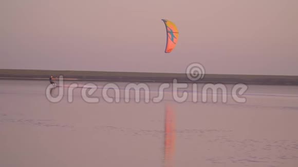 慢镜头拍摄湖面上的人控制着一只训练风筝视频的预览图