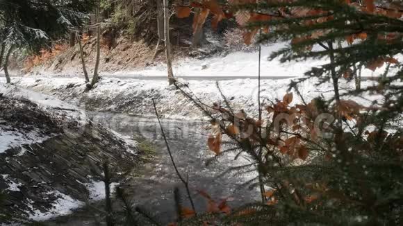 在令人惊叹的冬季森林中快速流动的河流和快速的水流形成泡沫的图片全景视频的预览图
