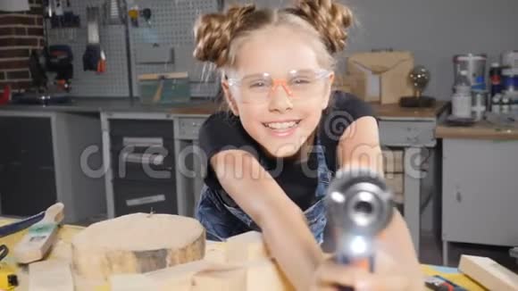 10岁的木木工女的画像手持电子钻对着镜头摆姿势小小的建筑理念高清高清视频的预览图