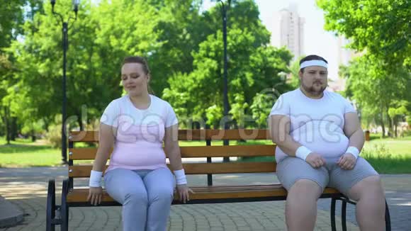 两个肥胖可爱的人坐在长凳上太害羞了不敢认识视频的预览图