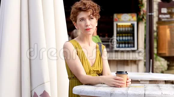 迷人的女人在户外喝咖啡享受当下在咖啡馆休息夏季视频的预览图