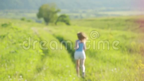 做女人夏天女孩带着草在田野的山上慢跑视频的预览图