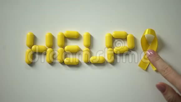 女性放置黄色丝带帮助词由药片制成的桌子儿童癌症视频的预览图