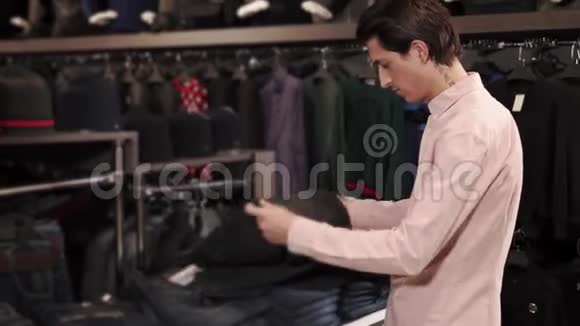一个年轻人选择牛仔裤作为他的脚他在一个大购物中心视频的预览图