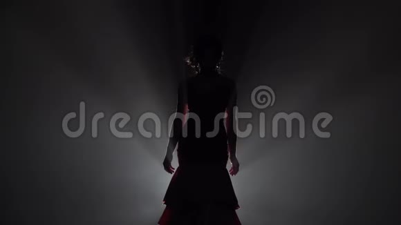 女孩跳着流动的动作双手站在背后从后面的光烟雾背景慢动作视频的预览图