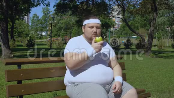 在户外慢跑后肥胖的年轻人吃苹果午餐适当添加维生素视频的预览图
