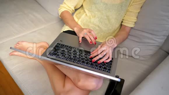 慢动作女孩坐在床上在笔记本上上网视频的预览图
