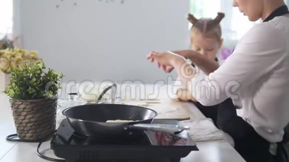 妈妈和女儿在早上的厨房做奶酪薄饼女人解释烹饪技术视频的预览图