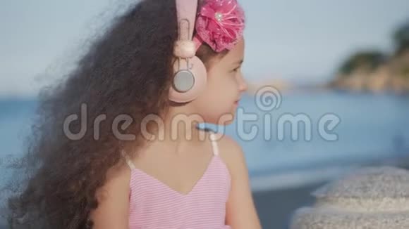 一个留着卷发的可爱的孩子的肖像穿着粉色衣服穿着粉色花朵的白种人小女孩夏天视频的预览图