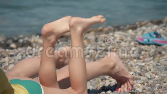 人们在阳光下在海里洗澡在海滩上洗澡和玩游戏海滩上的游客从大海的鹅卵石视频的预览图