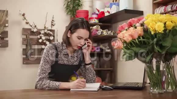 花店年轻的老板娘正在用电话和写信来订购商品视频的预览图