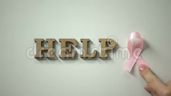 帮助词和粉红色丝带在桌子上乳腺癌和女性健康保护视频的预览图