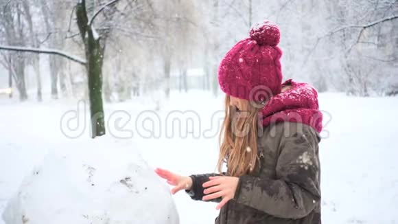 下雪时女孩在堆雪人视频的预览图