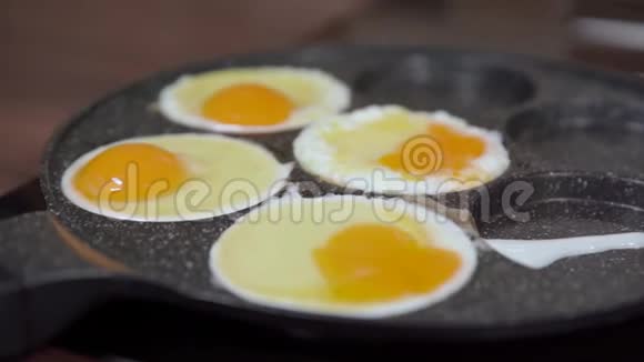 在厨房里用平底锅准备鸡蛋全家人的早餐视频的预览图