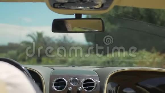 男子驾驶豪华轿车在度假城市的道路上行驶交通方向视频的预览图