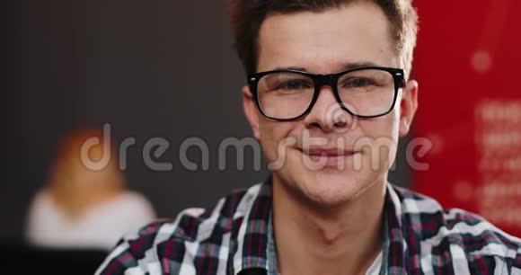 戴眼镜的年轻人笑得直挺挺的视频的预览图