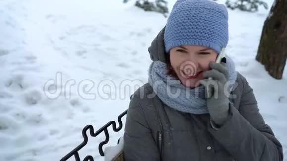 冬季公园的成年女人在打电话视频的预览图
