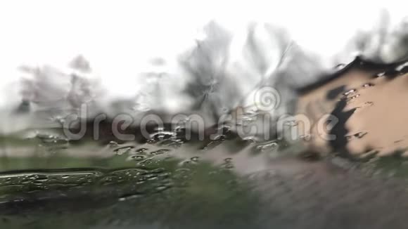 多云背景的窗户玻璃表面有雨滴雨滴的自然模式在雨中开车从这里看视频的预览图