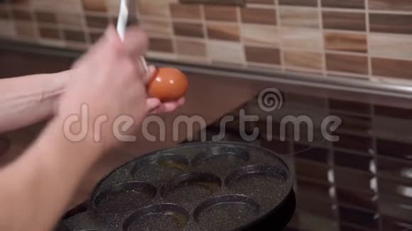 在厨房里用平底锅准备鸡蛋全家人的早餐视频的预览图