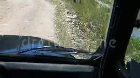 POV驾驶吉普车在绿色植物之间的崎岖道路上行驶视频的预览图