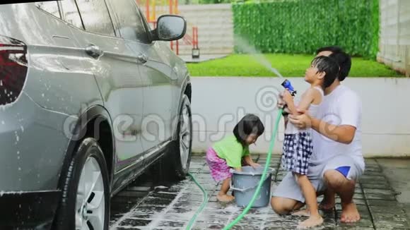 年轻的父亲教儿子洗车视频的预览图