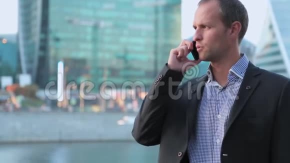 智能手机上的男人年轻的商人在智能手机上说话使用移动电话的休闲城市职业商人视频的预览图