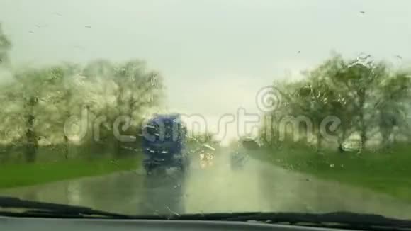 在雨中汽车沿着道路行驶并从挡风玻璃上移除液滴视频的预览图