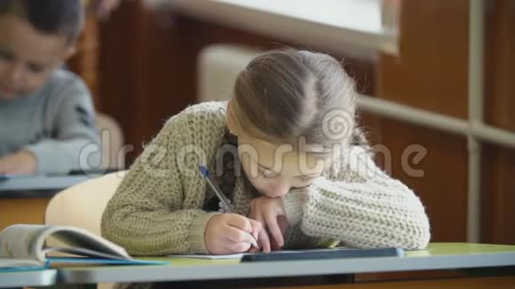 女孩坐在书桌前写字视频的预览图