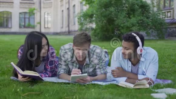 混合种族的人在大学校园的草坪上休息享受业余爱好视频的预览图