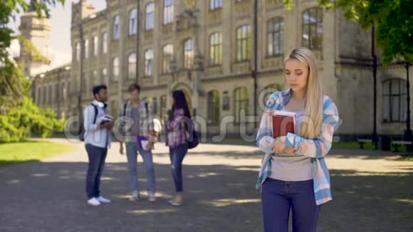 孤独的女孩远离朋友对大学里的流言蜚语感到不安视频的预览图