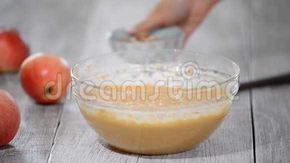 厨房里的厨师用抹刀混合在玻璃碗里在面糊中加入核桃视频的预览图