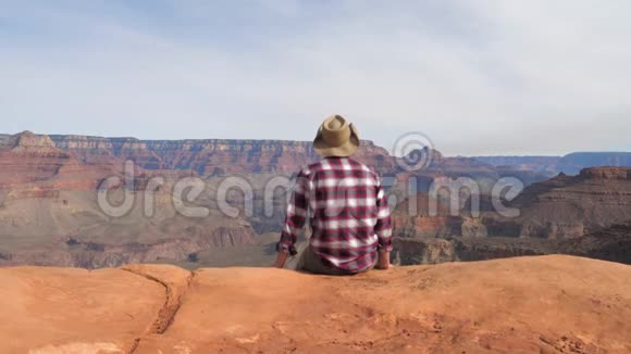 一个徒步旅行者坐在那里独自欣赏着大峡谷的壮丽景色视频的预览图