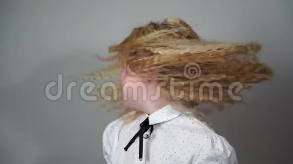 慢动作的美留着长发的女学生在灰色的背景上摇头视频的预览图