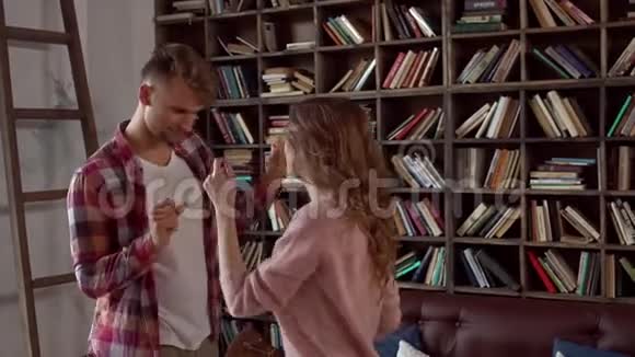 年轻夫妇在家一起在情人节图书馆跳舞活跃视频的预览图