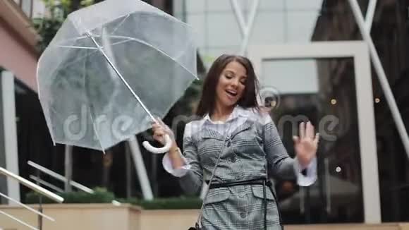 快乐的年轻女商人拿着雨伞跳舞检查雨是否停了她微笑着享受雨的结束视频的预览图