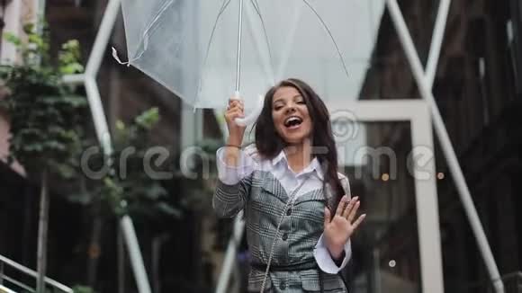 快乐的年轻女商人拿着雨伞跳舞检查雨是否停了她微笑着享受雨的结束视频的预览图