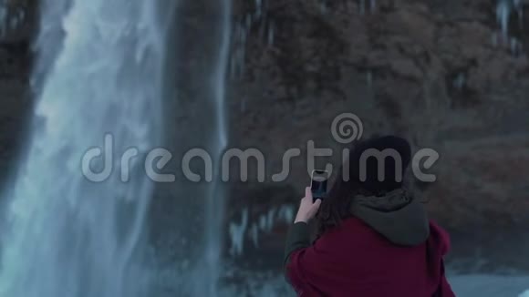 旅行女孩拍瀑布照片视频的预览图