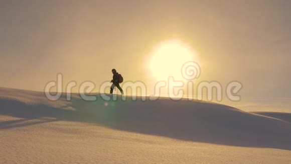 带着相机和三脚架的登山者正在雪中沿着全息图的顶部行走冬天的摄影师旅行者视频的预览图