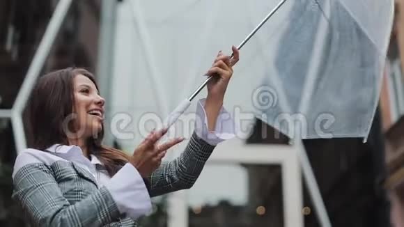快乐的年轻女商人拿着雨伞跳舞检查雨是否停了她微笑着享受雨的结束视频的预览图