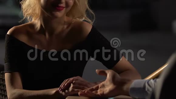 一对夫妇坐在露台的桌子上女的把她的手放在男的身上调情视频的预览图